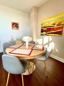 a dining room table with chairs and a painting on the wall at Apartment Villa am Markt in Aurich