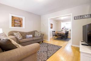 a living room with a couch and a television at Two DC Rowhouses Large Groups Sleeps 21 in Washington, D.C.