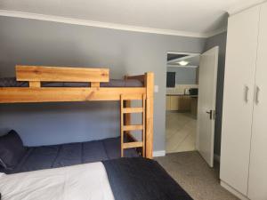 a bedroom with a bunk bed and a bathroom at INNIKOL 55 in Mossel Bay