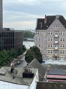 Modernes Loft mitten über dem Kiez auf St.Pauli! في هامبورغ: اطلالة على مدينة بها نهر ومباني