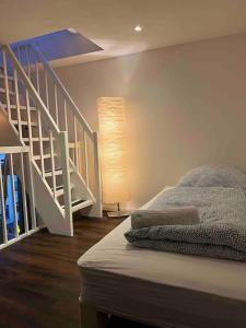 a bedroom with a bed and a white staircase at Modernes Loft mitten über dem Kiez auf St.Pauli! in Hamburg