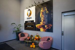 格但斯克Maya's Apartments的大堂设有2把粉红色的椅子和喷泉