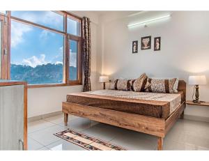 a bedroom with a bed and a large window at Hills View Paradise ,Shimla in Shimla