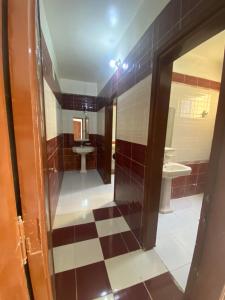 a bathroom with a checkered floor and a mirror at Hadi Guest House in Luxor