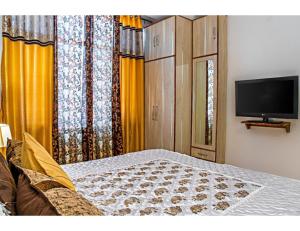 a bedroom with a bed and a flat screen tv at Hills View Paradise ,Shimla in Shimla