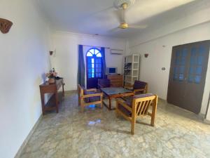 Hadi Guest House في الأقصر: غرفة معيشة مع طاولة وكراسي ونافذة