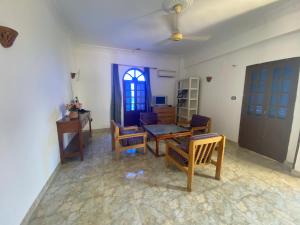 sala de estar con mesa, sillas y ventana en Hadi Guest House en Luxor