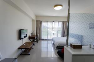 a bedroom with a bed and a desk and a television at 漫步月眉民宿 in Guanshan