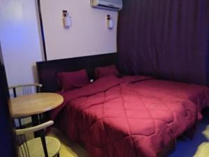 1 dormitorio con cama roja y mesa en Garden City House Hotel, en El Cairo