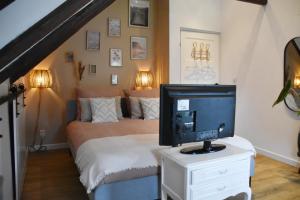 um quarto com uma cama e uma televisão numa mesa em Bed en Breakfast Studio Raif - Authentiek en sfeervol overnachten em Veendam