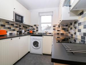 a kitchen with a washer and dryer in it at The Kate Kennedy Apartment in St Andrews