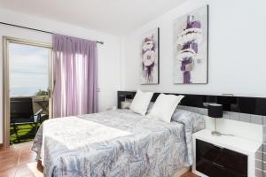 - une chambre blanche avec un lit et une télévision dans l'établissement Family Sea View Townhouse, à El Médano