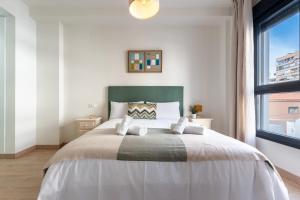 a bedroom with a large bed with a large window at MalagaSuite Comfortable Home 2 in Málaga