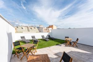 a patio with chairs and tables on a roof at MalagaSuite Comfortable Home 2 in Málaga