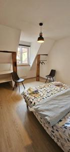 a bedroom with a bed and two chairs in it at Corps de ferme traditionnel in Lembach