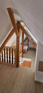 a attic room with a staircase with wooden beams at Corps de ferme traditionnel in Lembach