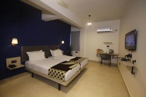 a bedroom with a large bed and a desk in it at Virohaa Garden Hotel in Ghaziabad