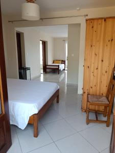 um quarto com uma cama e uma cadeira em Suite parentale Villa au bord de la mer chez Saloua em Bouéni