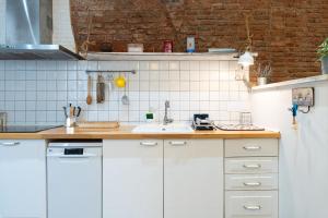 a kitchen with white cabinets and a sink at Hauzify I Casa d'Anselm Clavé in Calella