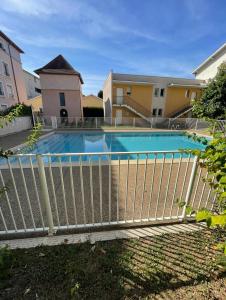 una recinzione intorno alla piscina in un edificio di Appartement avec place de parking et piscine a Villefranche-sur-Saône