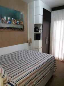 南聖卡埃塔諾的住宿－O Melhor Apart-Hotel, da Cidade!，一间卧室配有带条纹毯子的床