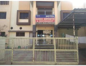 a hotel with a gate in front of a building at Hotel Shree, Somnath in Somnath