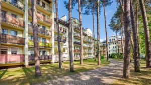 una fila di alberi di fronte a un edificio di Apartamenty Sun & Snow Morskie Oko a Międzyzdroje