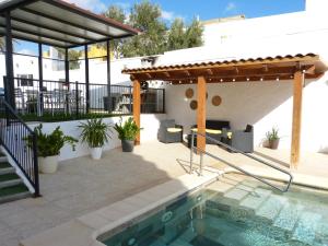 eine Terrasse mit einem Pool und einer Pergola in der Unterkunft Villa Alto Arena piscina privada climatizada in Ingenio