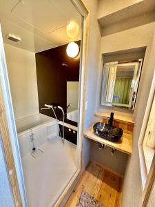 uma pequena casa de banho com um lavatório e um espelho em Fuji Dome Glamping em Fujikawaguchiko