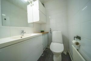 a white bathroom with a toilet and a sink at Arctic Penthouse in Rovaniemi