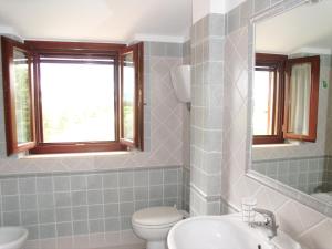 La salle de bains est pourvue de toilettes, d'un lavabo et d'un miroir. dans l'établissement B&B La Casa Fra Gli Olivi, à Marsciano