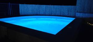 una gran bañera con agua azul en una habitación oscura en villa chopo, en Alhama de Granada