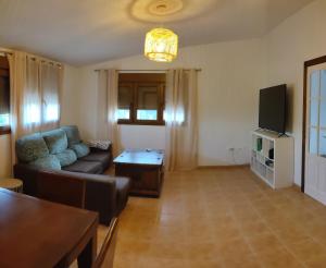 sala de estar con sofá y TV en villa chopo, en Alhama de Granada