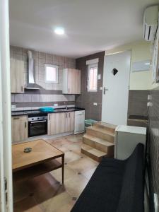 una cocina con armarios de madera y una mesa y escaleras. en Casa económica Madrid, en Leganés