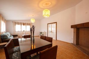 sala de estar con mesa de comedor y chimenea en villa chopo, en Alhama de Granada