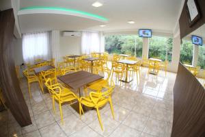 uma sala de jantar com mesas e cadeiras amarelas em HOTEL JOINVILLENSE em Joinville