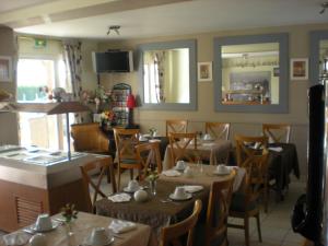 Les Augustines في كويند: غرفة طعام مع طاولات وكراسي في مطعم