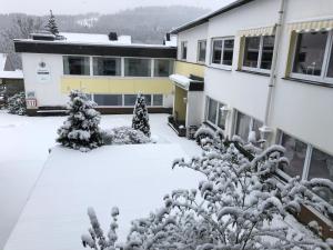 a snow covered yard in front of a building at Berghotel Natura Bed & Breakfast in Winterberg