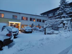 a snow covered parking lot in front of a building at Berghotel Natura Bed & Breakfast in Winterberg