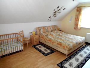 ein kleines Schlafzimmer mit einem Bett und einem Kinderbett in der Unterkunft Ferienhaus Barbara in Masserberg