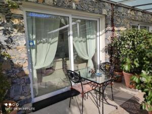 a glass table and chairs on a patio at La Casa degli Ulivi in Chiavari +7 photos
