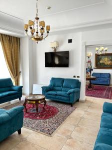 ein Wohnzimmer mit blauen Sofas und einem TV in der Unterkunft D'Angelo Palace Hotel in Mazara del Vallo