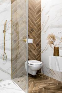 a bathroom with a toilet and a glass shower door at OBERŻA POD RÓŻĄ restauracja, sauny, jacuzzi in Nowy Targ