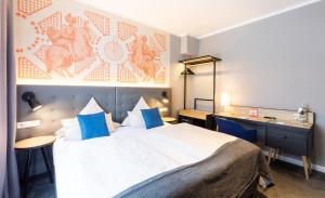 ein Hotelzimmer mit einem großen Bett und einem Schreibtisch in der Unterkunft YORS Boutique Hotel in Hannover