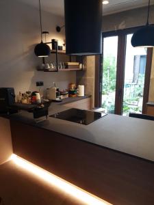 eine Küche mit einer Spüle und einer Theke mit Lampen in der Unterkunft Poros Maisonette Apartment - Neorio in Poros