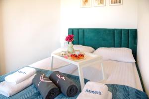 Una cama con almohadas y una mesa con una flor. en Maya's Apartments, en Gdansk