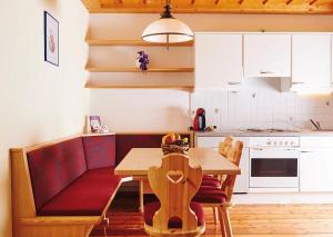 a small kitchen with a table and a red couch at Apartments by GMS in Katschberghöhe +17 photos