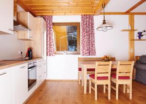 a kitchen and dining room with a table and chairs at GMS Holidays in Katschberghöhe +9 photos