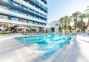 une piscine en face d'un bâtiment dans l'établissement Port Alicante City & Beach, à Alicante