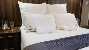 a bed with white pillows and two towels on it at Sedibeng Guest House in Vereeniging